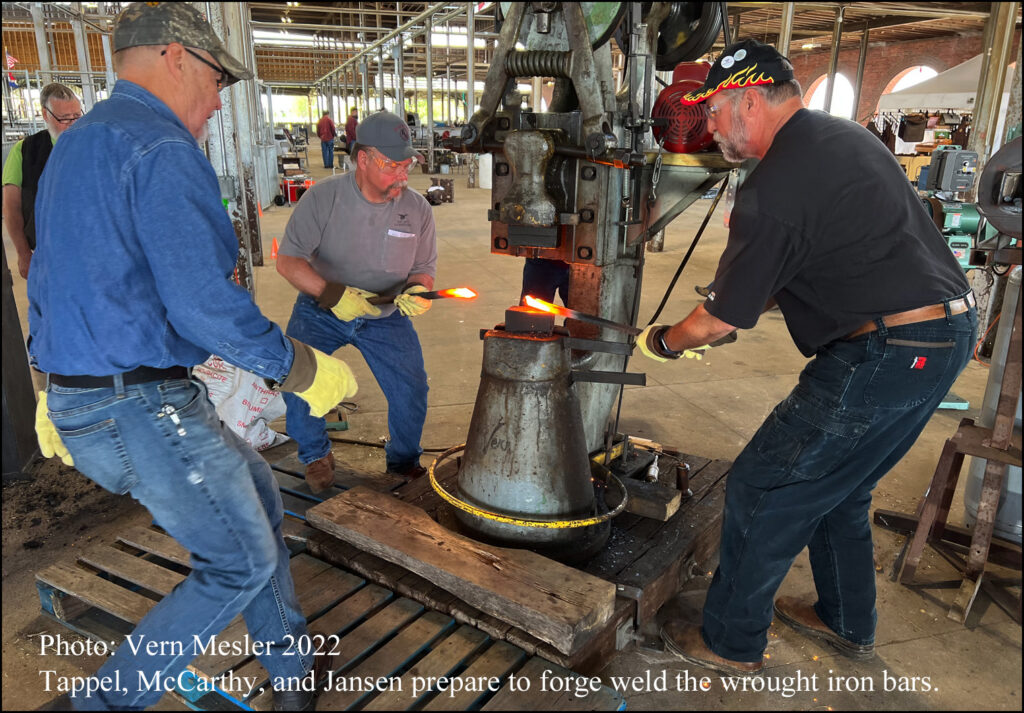 Three Craftsmen Working on Forge Weld the Wrought Iron Bars