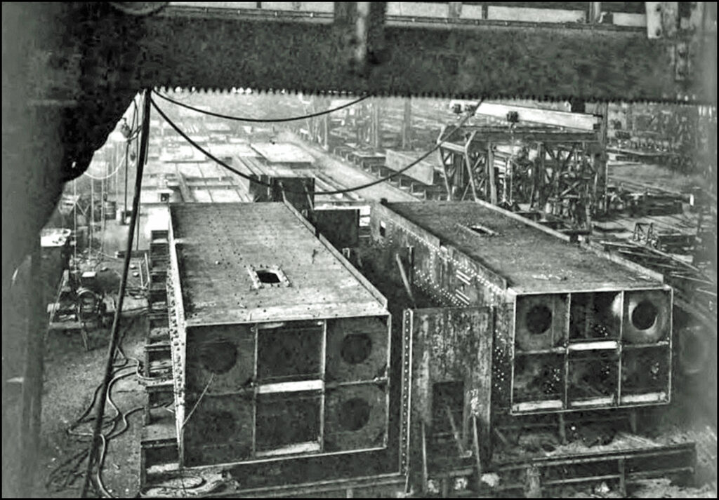 View of column-sections at boxing skids. One column-section has been riveted and is ready for the milling operation; the other is in the reaming and drilling stage. (The Golden Gate Bridge Report of the Chief Engineer, p. 238)