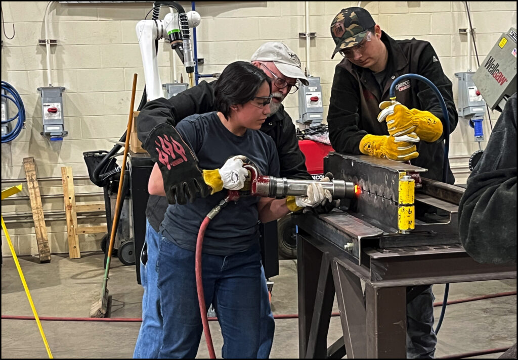 Photo: Nan Jackson, 2024 Structural Fabrication student drives a rivet during demo at Lansing Community College West Campus.